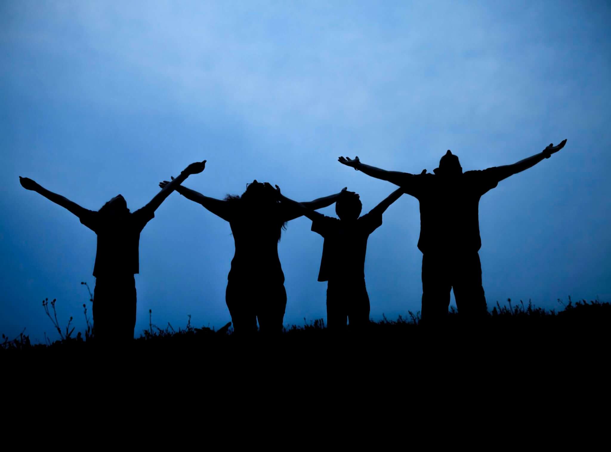 The family from three persons welcomes the sunset sun.